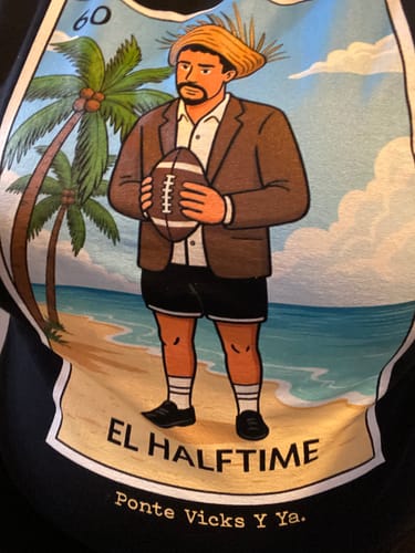 Customer's close-up of the 'El Halftime OG T-Shirt' graphic, showing a cartoon man holding a football on a beach.