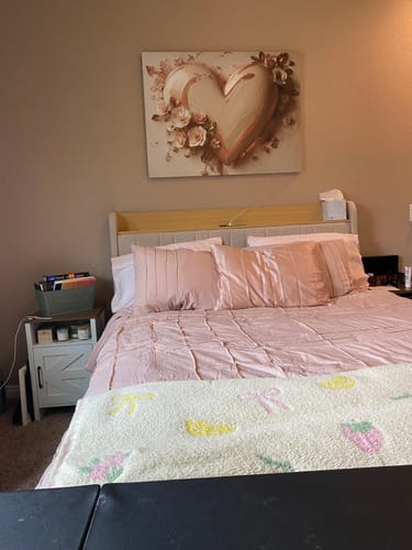 Customer's Blushbound Heart canvas art hanging on the wall above a bed with matching pink bedding.
