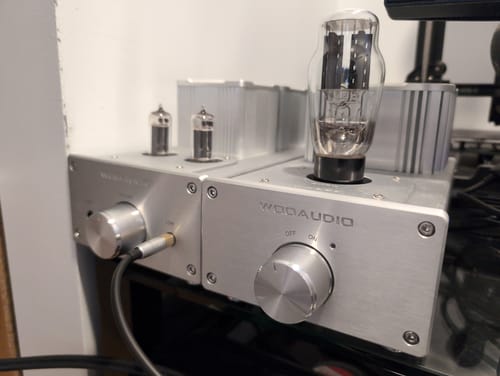 Customer's silver Woo Audio WA6-SE (2nd Gen) dual-chassis amplifier with its large tubes illuminated on a desk.