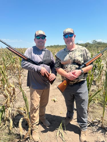 Customers wearing XCOR PRO hearing protection while standing in a cornfield with shotguns.