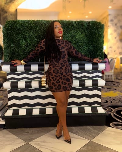 Reviewer posing in the long-sleeved Naked Print Mini Dress, showing its bodycon fit.