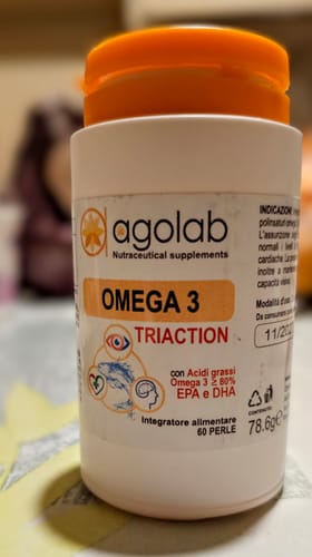 Recensore mostra il flacone bianco con tappo arancione dell'integratore Omega 3 Triaction.