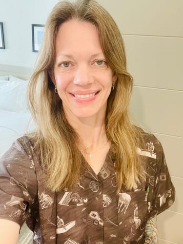 A smiling reviewer wears the sepia-toned "Wicked Winds" shirt with its detailed tornado pattern.