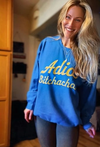 Customer smiling while wearing a comfy, oversized blue Adios Bitchachos Sweatshirt.