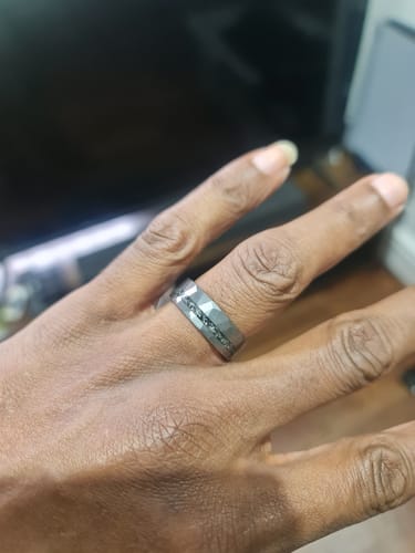 Customer wearing the hammered, dark Astorix ring on their finger, showing the meteorite inlay.