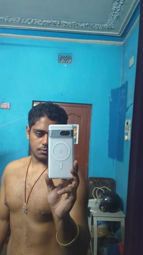 Reviewer taking a mirror selfie showing the white Magsafe case on their Google Pixel 7.