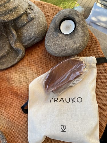 Cliente muestra el Monedero Café en su envoltorio plástico junto a su bolsa de tela.