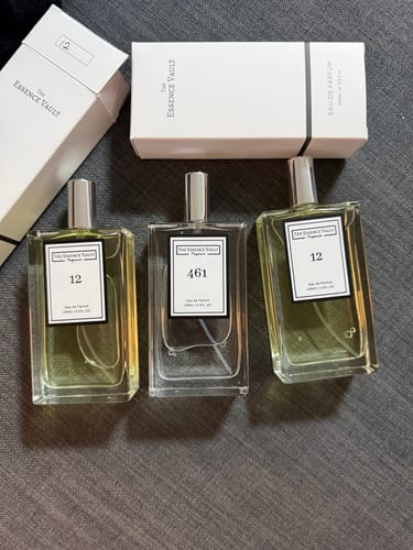 Reviewer's empty bottle of No. 461 perfume shown with two other full perfume bottles and white packaging.