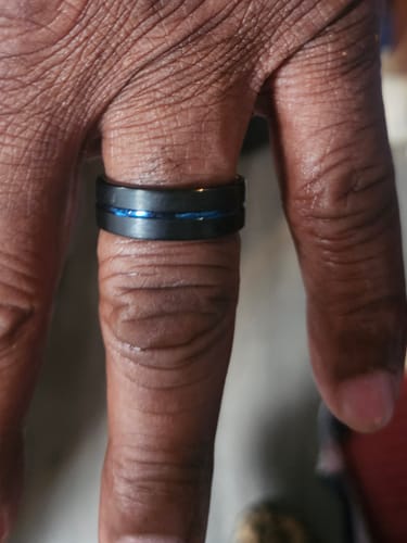 Close-up of a customer's hand wearing the black Stratus ring with a blue groove.