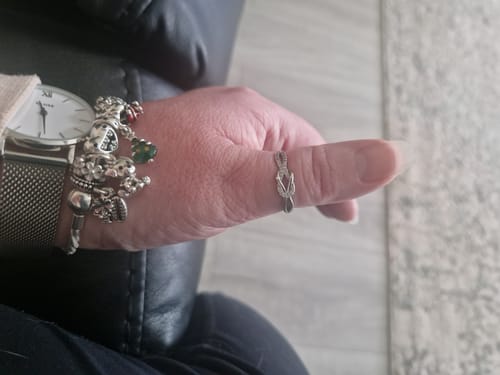 Reviewer wearing the silver Best Bitches Knot Ring on their thumb.