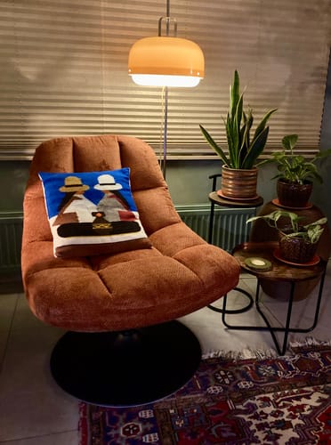 Klant toont de comfortabele Drift Draaibare Fauteuil in een sfeervolle woonkamer.