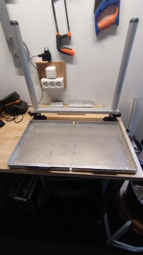 Recensent toont twee zilveren SEATBOX LEG poten gemonteerd op een zelfgemaakt voetplateau in een werkplaats.