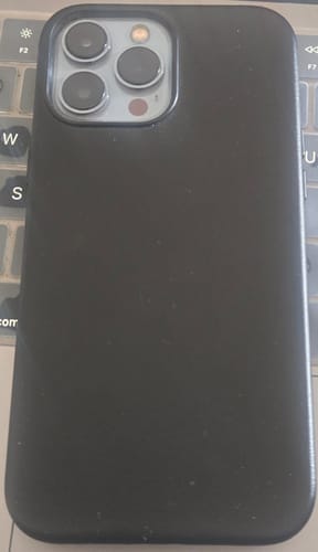 Customer's phone in a black case, highlighting the raised protection around the camera.