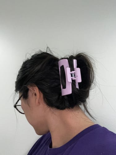 Customer's dark hair held securely in an updo by a light purple cloud clip.