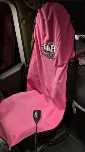 A customer's pink Waterproof Car Towel Seat Cover draped over the driver's seat inside a truck.