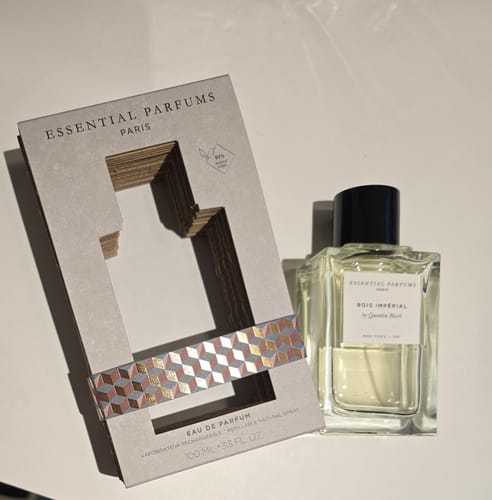 Il recensore mostra il flacone di profumo Bois Imperial accanto alla sua confezione in cartone ecologica.