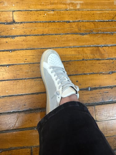 Close-up of the reviewer's SALMA sneaker showing the perforated white toe and grey mesh side.