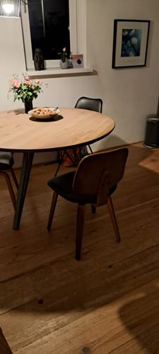 Recensent toont de vtwonen Classic eetkamerstoel aan een houten eettafel in een sfeervolle eetkamer.