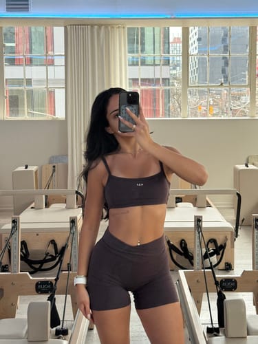 Reviewer in a studio wearing the espresso V Short, showing the crossover v-waistband.