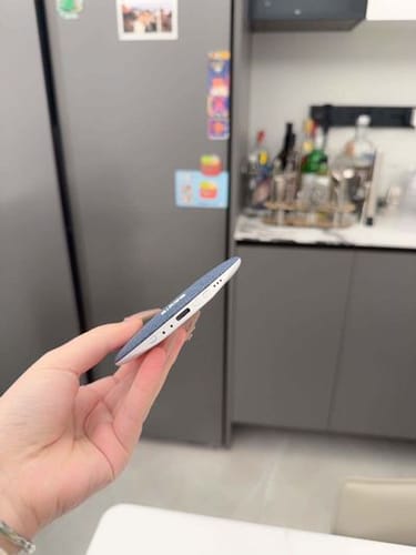 Reviewer holding the ultra-thin Litlamp™ Pillow Speaker, showing its side profile with the charging port visible.