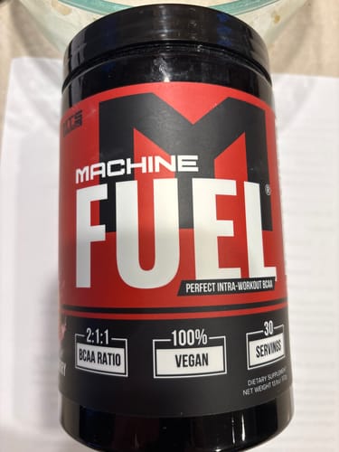 Customer's black and red container of Machine Fuel, highlighting the 2:1:1 BCAA ratio and 100% vegan claims.
