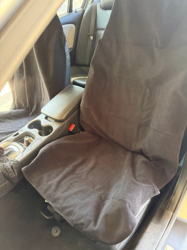 Customer's black Waterproof Car Towel Seat Cover draped over the front passenger seat of a car.
