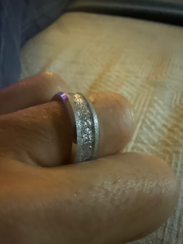 Close-up of a customer wearing the Aureum Silver ring, showing its sandblasted finish and textured silver-foil inlay.