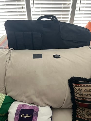 Reviewer's black SPOTMINDERS Tracking Card and charger laid out on a couch cushion in a living room.