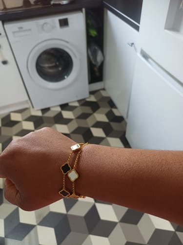 Customer wearing the Celine Clover Bracelet with black and white clover motifs on their wrist.