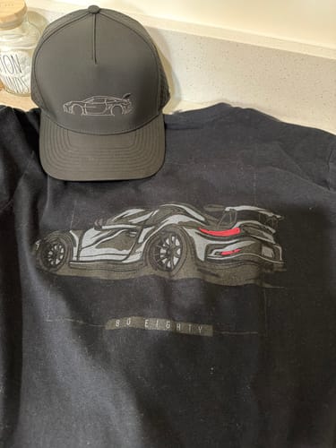 Customer's black 80Eighty DCG#85 Hat with an embroidered car outline, shown on top of a matching graphic t-shirt.