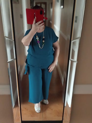 Reviewer in a mirror selfie wearing the Florida Teal Side Knot Set, showing the top, necklace, and wide-leg trousers.