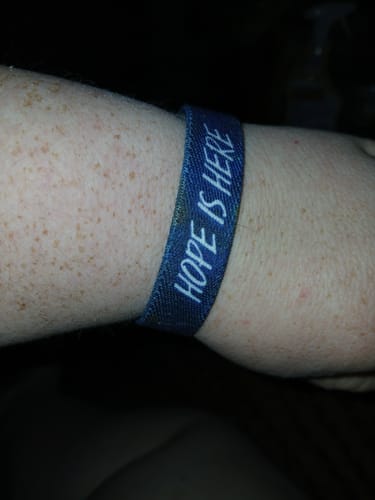 Close-up of a customer wearing the blue Hope Is Here Bracelet on their wrist.