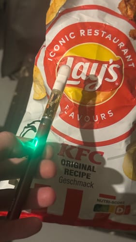 Customer holding the activated ROLLZ 510 thread battery, which is glowing with a bright green light.