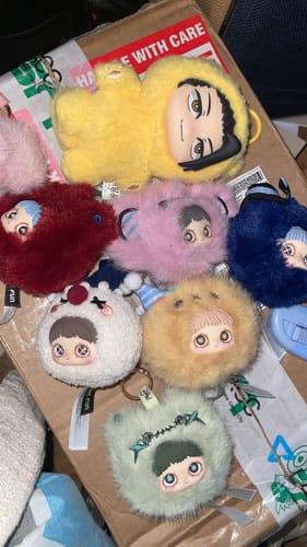 Reviewer's collection of colorful Maymei Crazy Circus Series plush keychains laid out on a cardboard box.