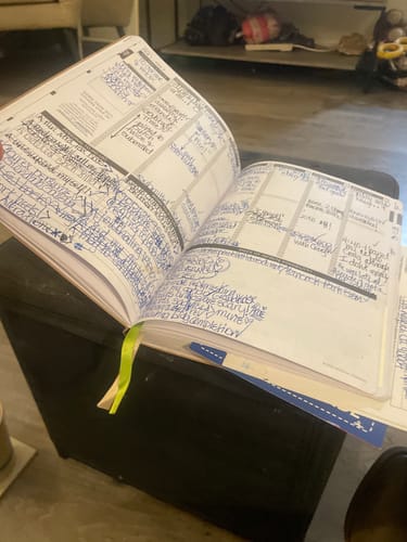 Customer's well-used Weekly 2026 Planner open, with pages filled with extensive blue handwriting.