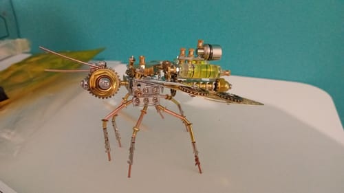 Customer's fully assembled Steampunk Bee with intricate metal parts on a white surface.