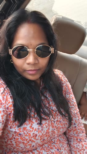 Customer wearing the Golden Oval Sunglasses with black lenses while sitting in a car.