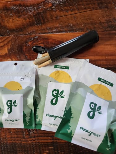 Customer's Cherry Dosi Do Pre-Rolls in an open black tube, with several branded pouches on a wooden table.