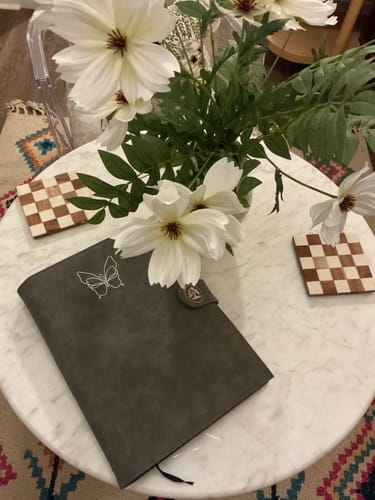 Reviewer's gray textured Luxury Cover for Dreambook + Planner, featuring a butterfly icon and snap closure on a marble table.