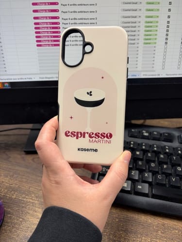 Reviewer holding a beige Kaseme phone case with a stylish 'Espresso Martini' graphic design at a desk.