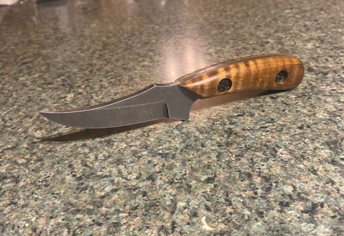 Customer shows a custom knife with a dark blade and wood handle, finished using the sanding belts.