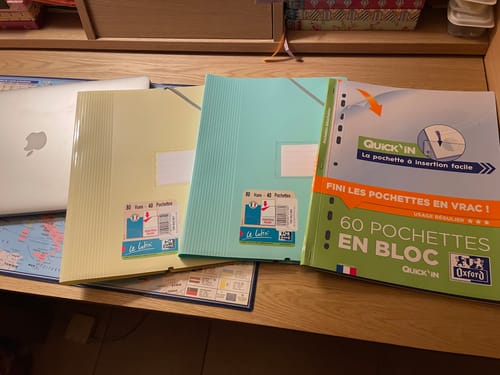 Le porte-vues Oxford jaune pastel d'un client, posé sur un bureau avec d'autres articles de la même marque.