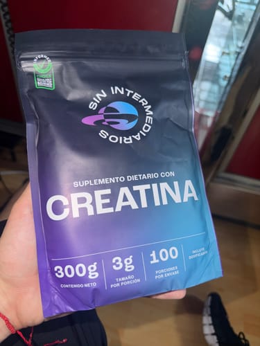 Un cliente sostiene el empaque de 300g del suplemento Creatina Monohidrato.