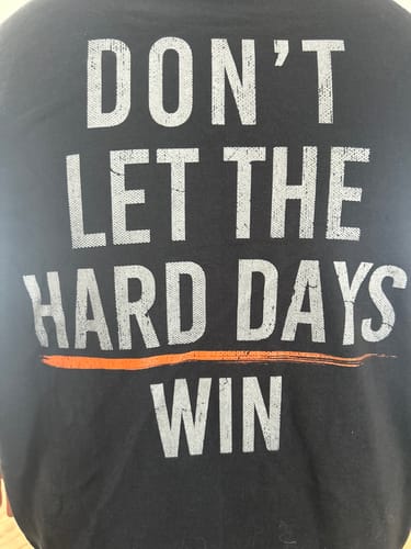 Close-up of the customer's black Hard Days - Hoodie, showing the 'Don't Let The Hard Days Win' back graphic.