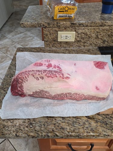 Reviewer's raw USDA Prime Brisket laid out on butcher paper on a kitchen counter.