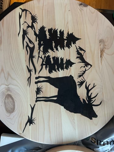 Customer's project using Wood Pre-Treatment, showing a sharp, detailed deer and forest design on a wood round.