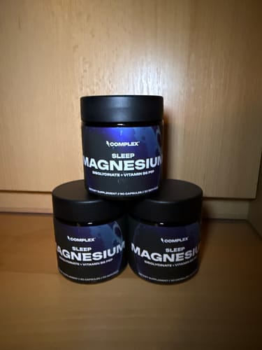 Customer's three black jars of Sleep Magnesium supplement, stacked in a pyramid.