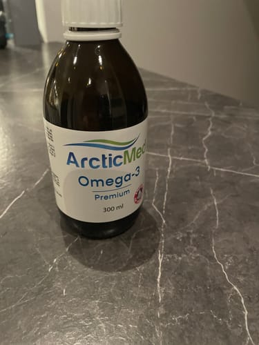 Recensentens flaska med ArcticMed Omega-3 Premium som står på en mörk bänkskiva.
