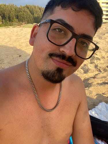Cliente usando la Cadena Cuban Link plateada en la playa, mostrando su brillo y resistencia.