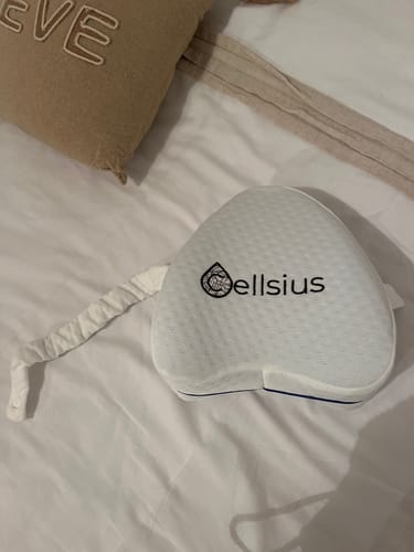 Le coussin orthopédique pour genoux Cellsius d'un client, posé sur un lit blanc.